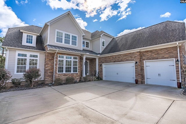 view of front of home with driveway, a standing seam roof, metal roof, a shingled roof, and a garage