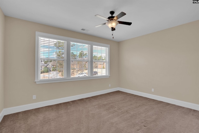 carpeted empty room featuring visible vents, baseboards, and a ceiling fan