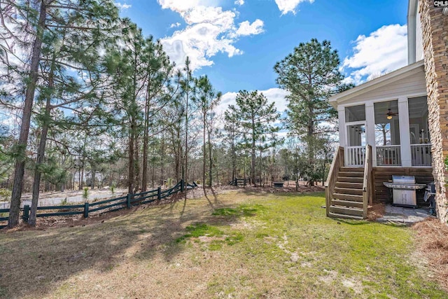 view of yard with stairway, fence, and a sunroom