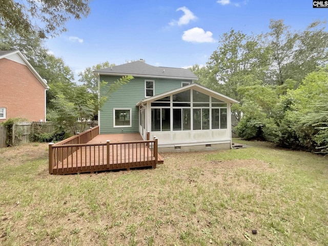 rear view of property with fence, a yard, a wooden deck, a sunroom, and crawl space