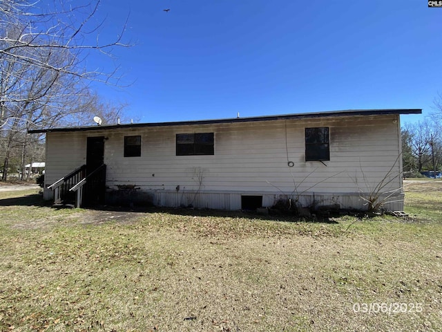 back of property featuring a yard and entry steps