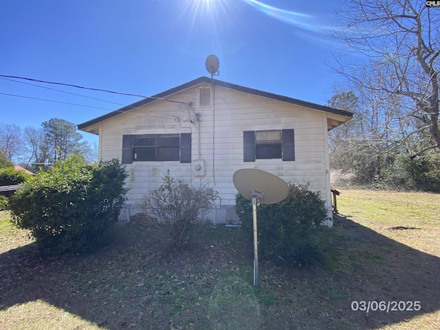 view of side of property with a lawn