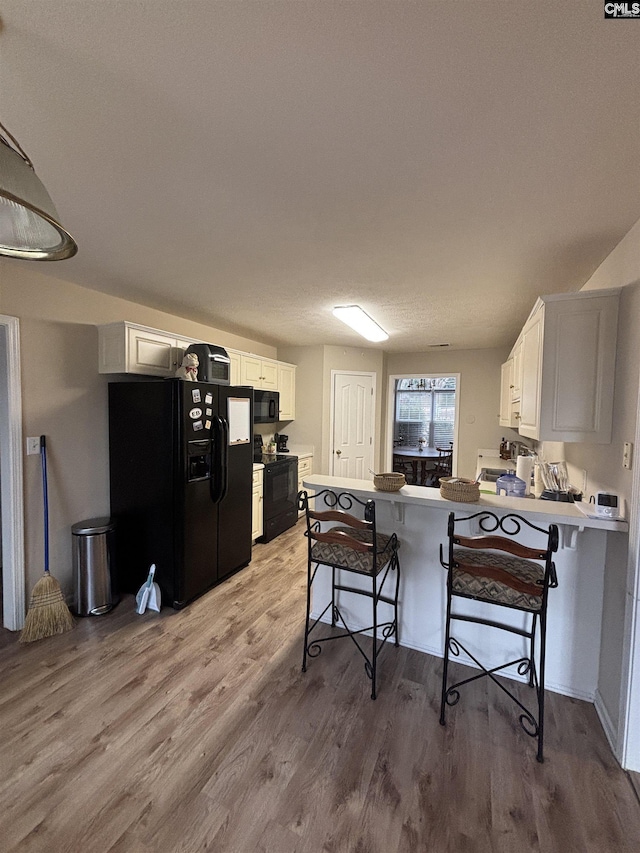416 Knotts Ct, Lexington, SC 29073 - kitchen with light wood-style flooring, black appliances, a peninsula, and white cabinetry
