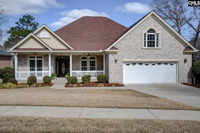 traditional-style home featuring a porch, concrete driveway, brick siding, and roof with shingles