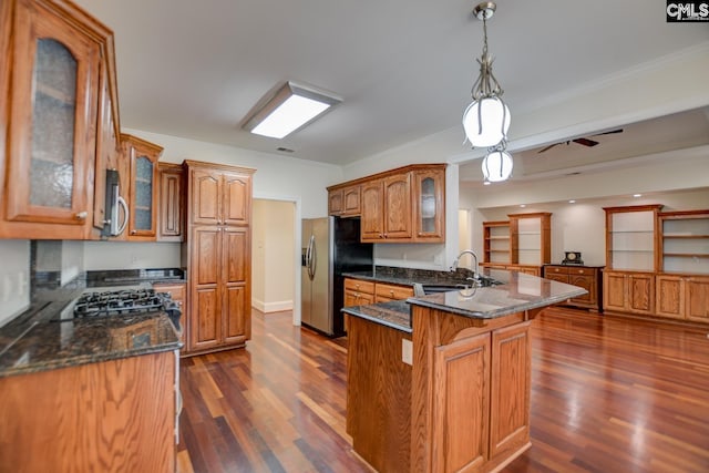 kitchen featuring ornamental molding, brown cabinets, a peninsula, stainless steel appliances, and a sink