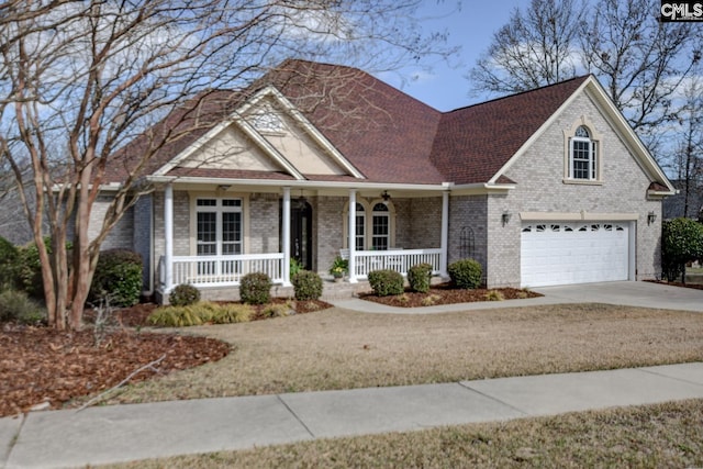 traditional-style home featuring a garage, a porch, concrete driveway, and brick siding