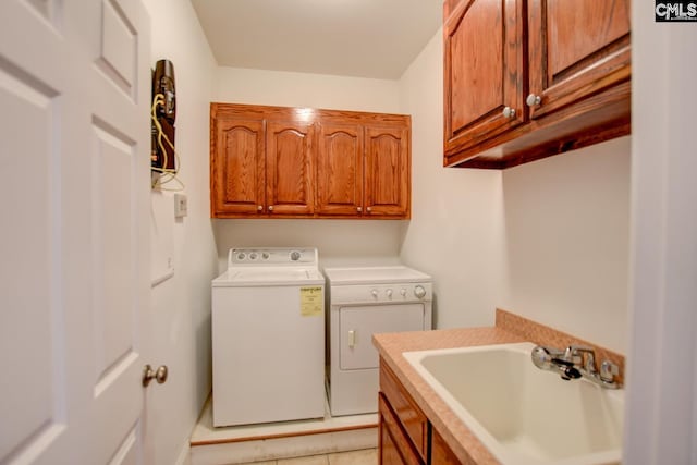 laundry area featuring washer and dryer, cabinet space, and a sink