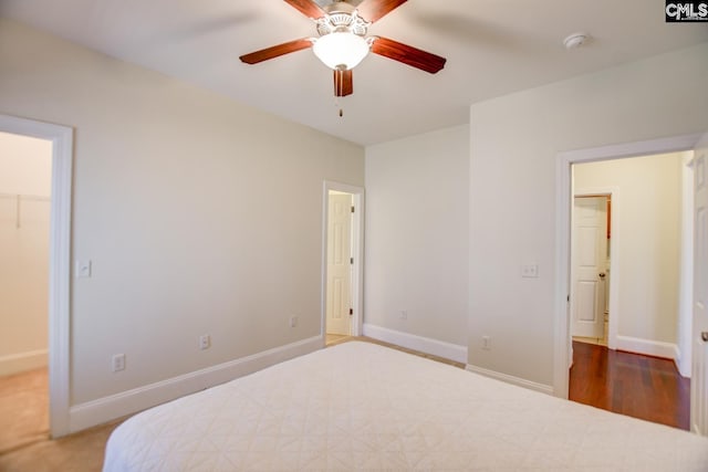 bedroom with a spacious closet and baseboards