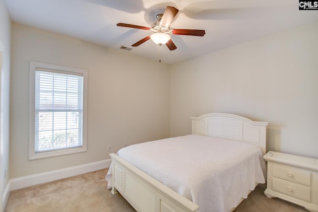 bedroom with visible vents, light colored carpet, a ceiling fan, and baseboards