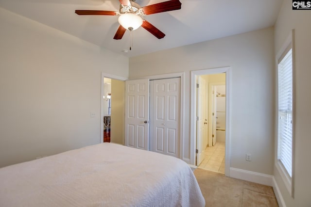 bedroom with ensuite bath, multiple windows, light colored carpet, and a closet