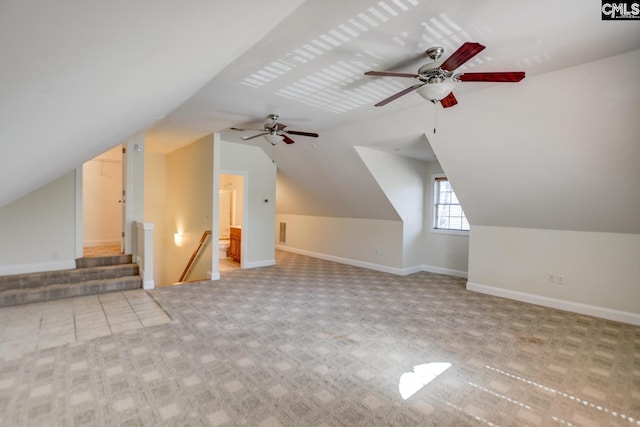 additional living space with baseboards, lofted ceiling, and light carpet