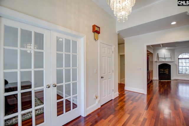 interior space with wood finished floors, french doors, baseboards, and ornamental molding