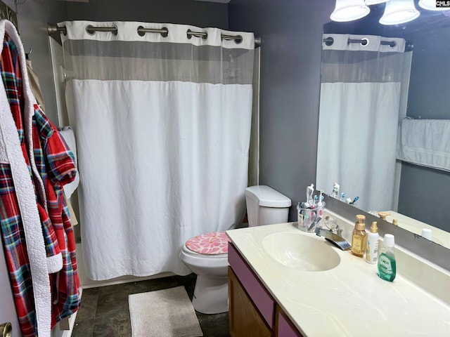 full bath featuring a shower with shower curtain, toilet, and vanity