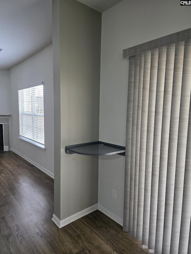 interior space featuring baseboards and dark wood-type flooring