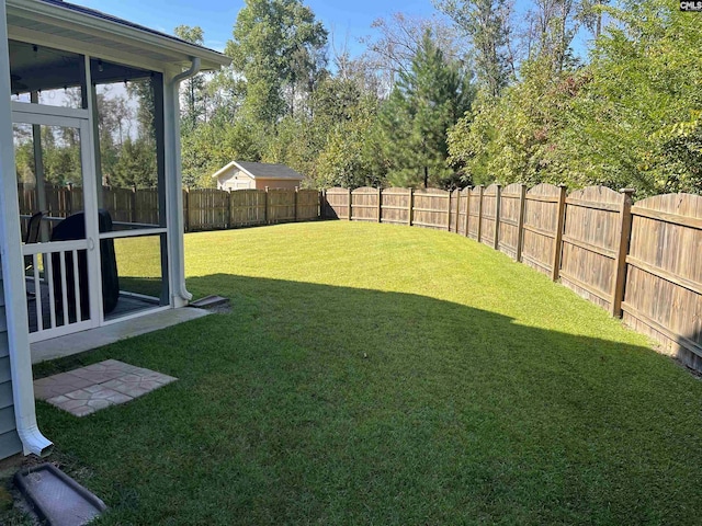 view of yard featuring a fenced backyard and a sunroom