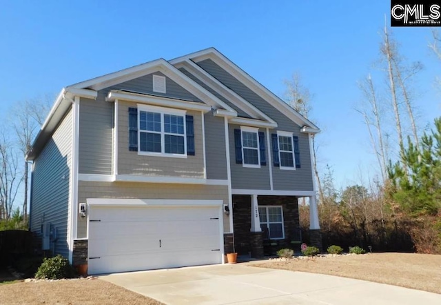 craftsman house featuring an attached garage, stone siding, and driveway