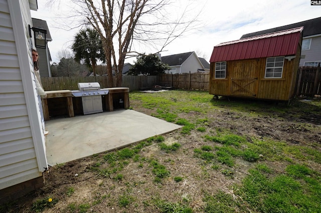 view of yard with a fenced backyard, a shed, an outdoor structure, and a patio