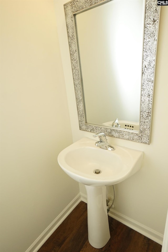 bathroom featuring a sink, baseboards, and wood finished floors