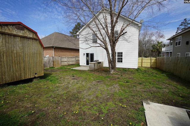 back of property featuring an outbuilding, a lawn, a patio, and a fenced backyard