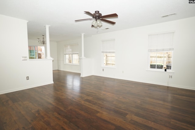 unfurnished living room featuring visible vents, ceiling fan with notable chandelier, dark wood-style floors, and ornate columns