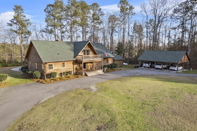 log-style house featuring a front yard, log exterior, a porch, and driveway