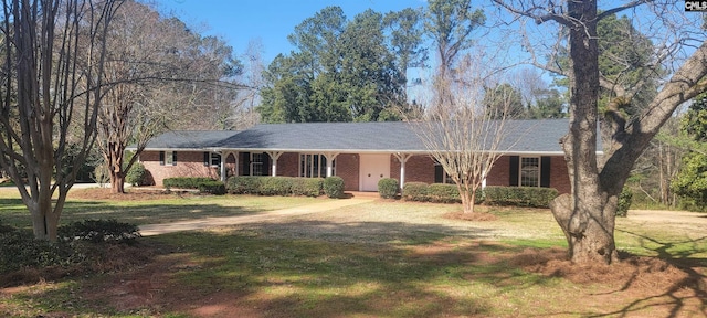 ranch-style house with brick siding, covered porch, and a front yard