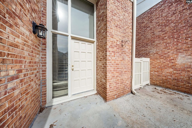 view of exterior entry featuring brick siding