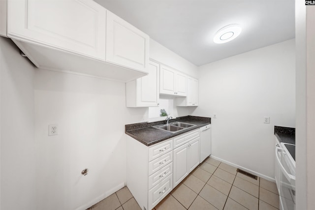 kitchen with visible vents, a sink, dark countertops, white cabinetry, and white appliances