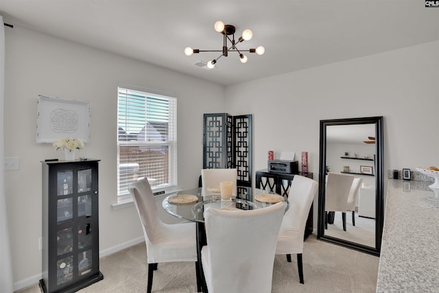 carpeted dining area with baseboards and a chandelier