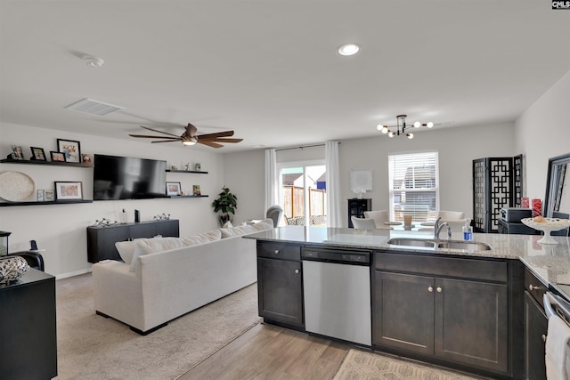 kitchen featuring visible vents, dishwasher, open floor plan, and a sink