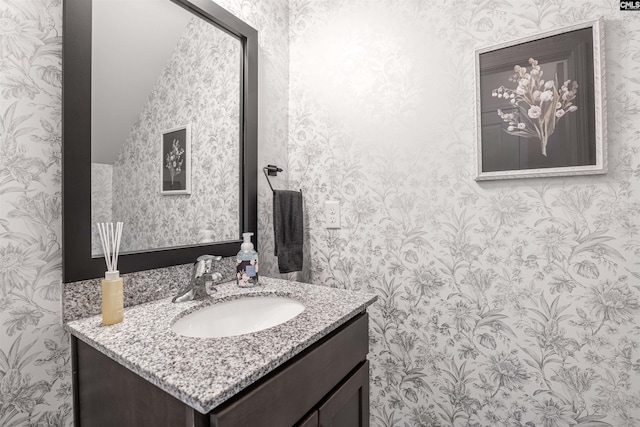 bathroom with wallpapered walls and vanity