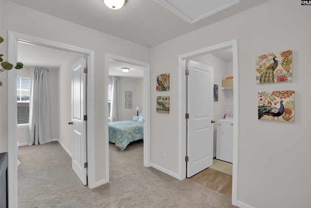 hall with baseboards, washer / dryer, and carpet flooring