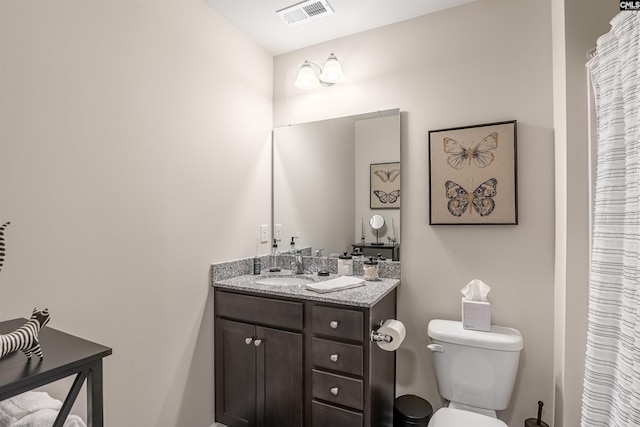 bathroom featuring visible vents, toilet, and vanity