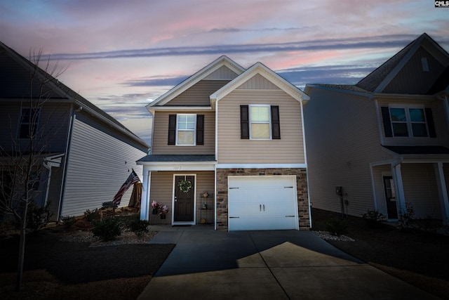 view of front of house featuring stone siding, an attached garage, board and batten siding, and driveway