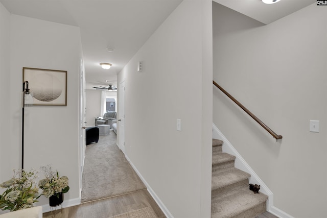 hallway with stairway, baseboards, and light wood-type flooring