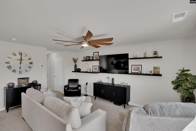 living area with baseboards, light colored carpet, visible vents, and ceiling fan