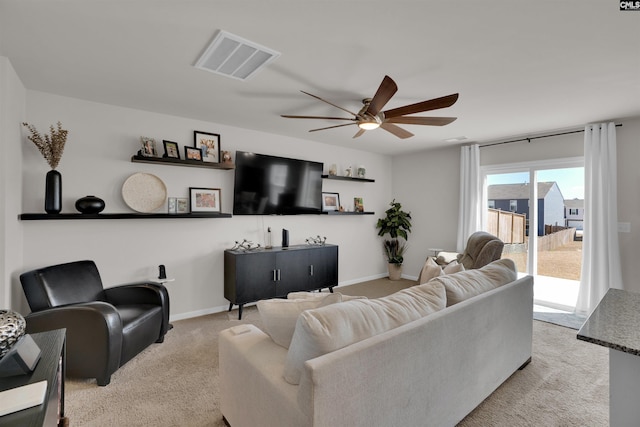 carpeted living area with visible vents, baseboards, and ceiling fan