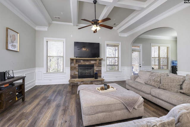 living room featuring a wealth of natural light, visible vents, beamed ceiling, and a fireplace