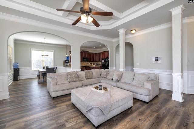 living room with dark wood finished floors, wainscoting, and crown molding