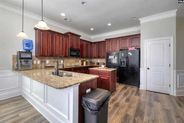 kitchen with dark wood finished floors, a sink, decorative backsplash, black appliances, and dark brown cabinets