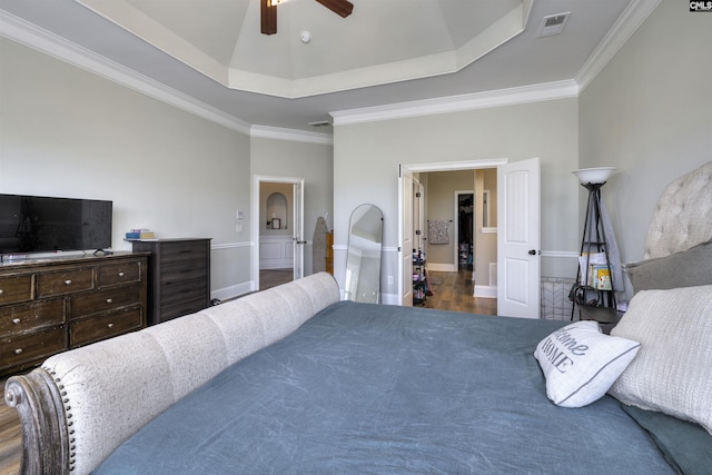 bedroom with visible vents, ceiling fan, a tray ceiling, and ornamental molding