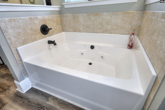 bathroom featuring wood finished floors and a bath