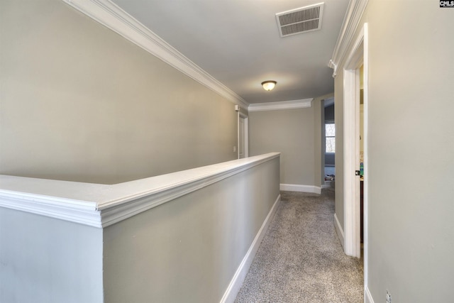 hallway featuring visible vents, carpet flooring, baseboards, and ornamental molding