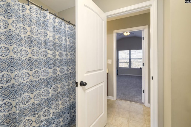 bathroom with tile patterned floors, curtained shower, and baseboards