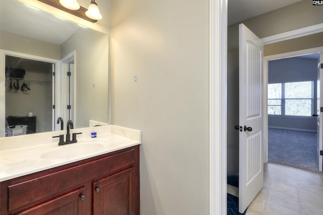 bathroom featuring tile patterned flooring, vanity, and baseboards