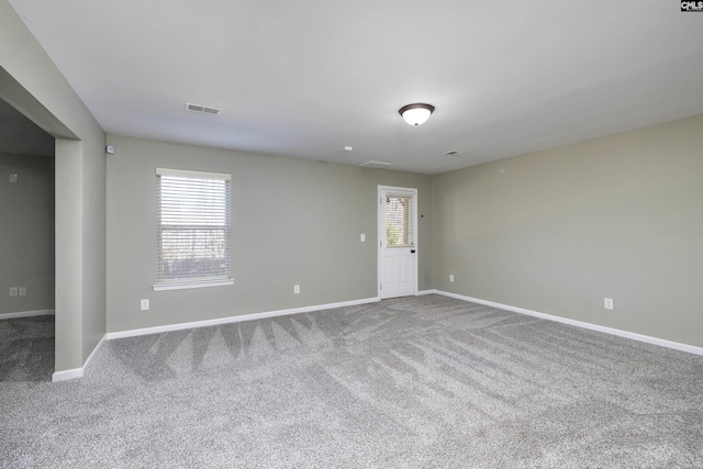 empty room with visible vents, baseboards, and carpet