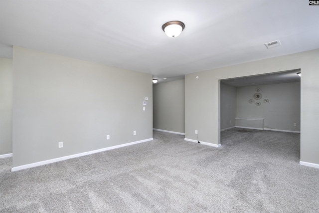 empty room with baseboards, visible vents, and carpet floors