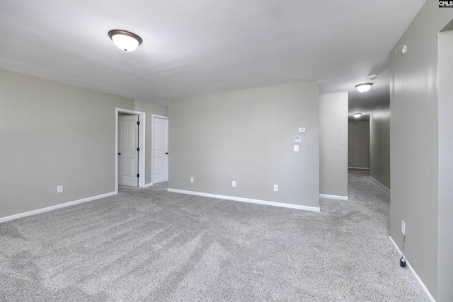 spare room with baseboards and carpet