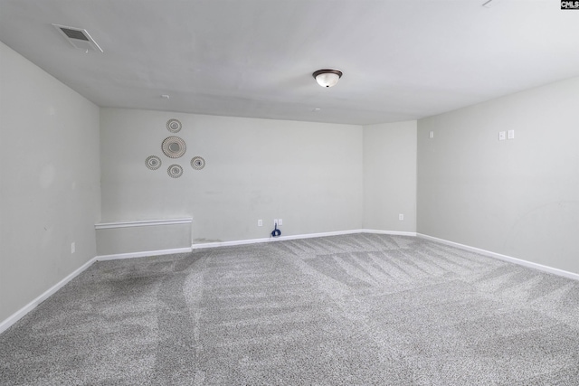 empty room featuring visible vents, carpet floors, and baseboards