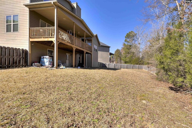 back of property with a yard, a fenced backyard, and a chimney